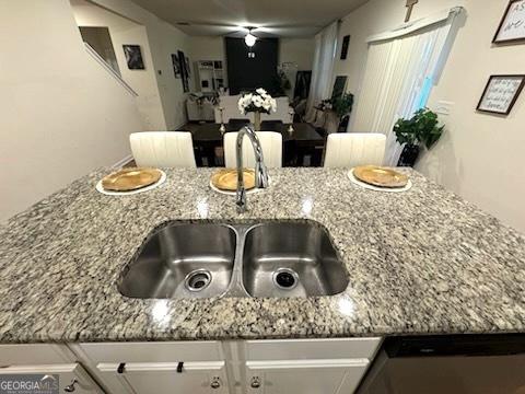 kitchen featuring light stone counters and sink