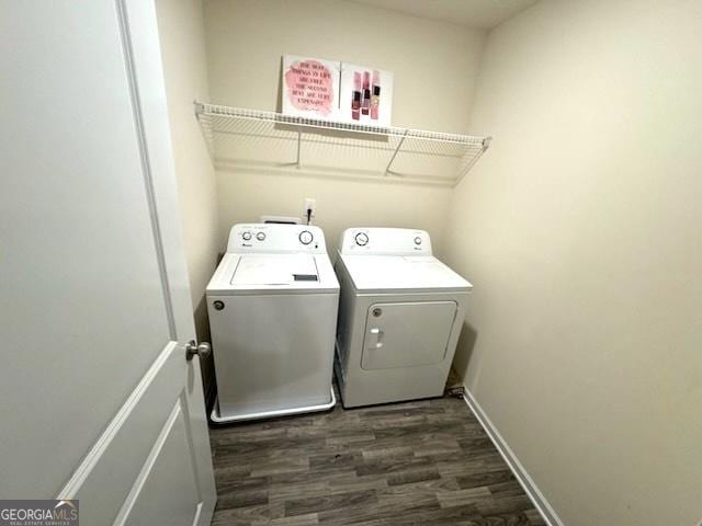 clothes washing area with dark hardwood / wood-style flooring and separate washer and dryer