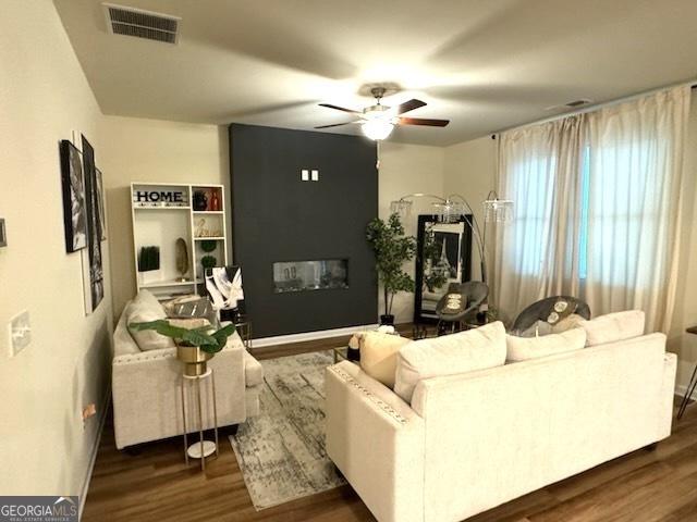 living room with ceiling fan and dark hardwood / wood-style flooring