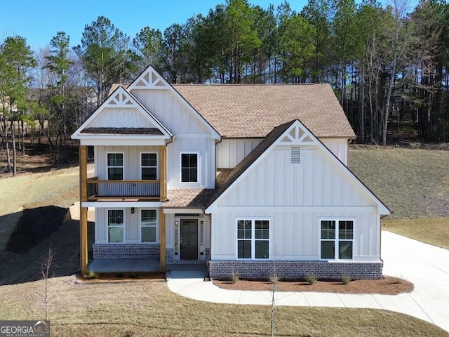 view of front of property featuring brick siding, board and batten siding, and a shingled roof