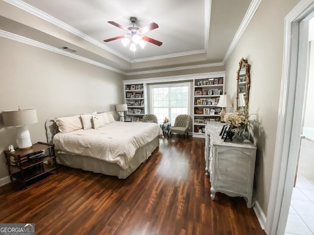 bedroom featuring ceiling fan, dark hardwood / wood-style floors, crown molding, and a tray ceiling