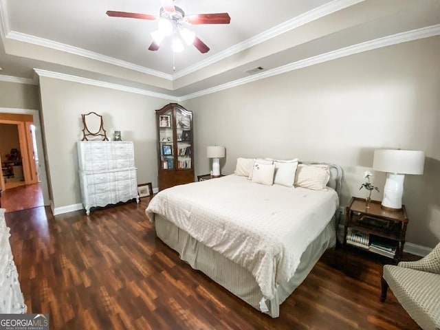 bedroom with a raised ceiling, ceiling fan, dark wood-type flooring, and ornamental molding