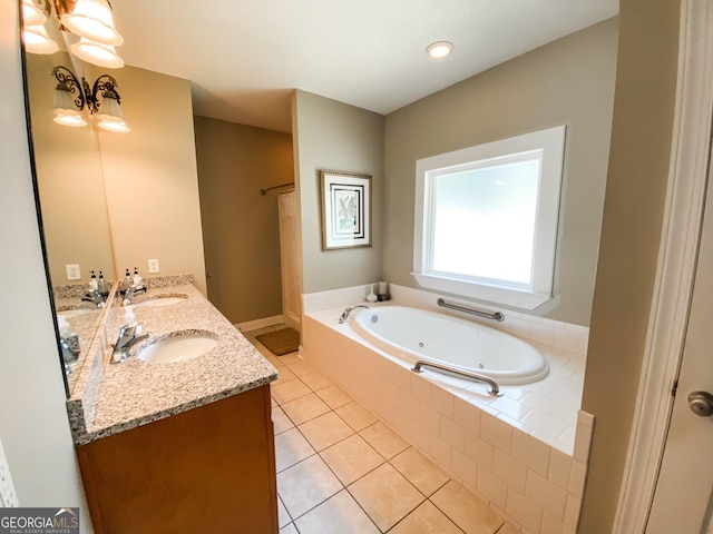 bathroom featuring tile patterned flooring, vanity, and tiled tub