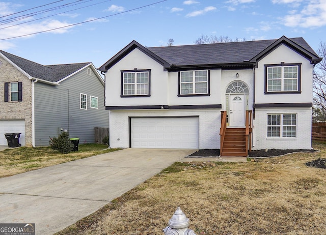 raised ranch with a garage and a front lawn