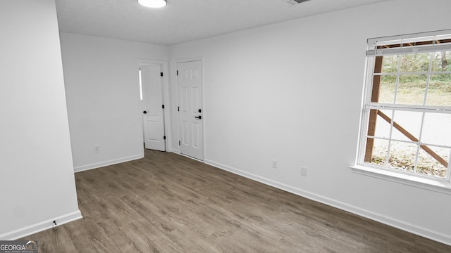 spare room with hardwood / wood-style floors and a healthy amount of sunlight