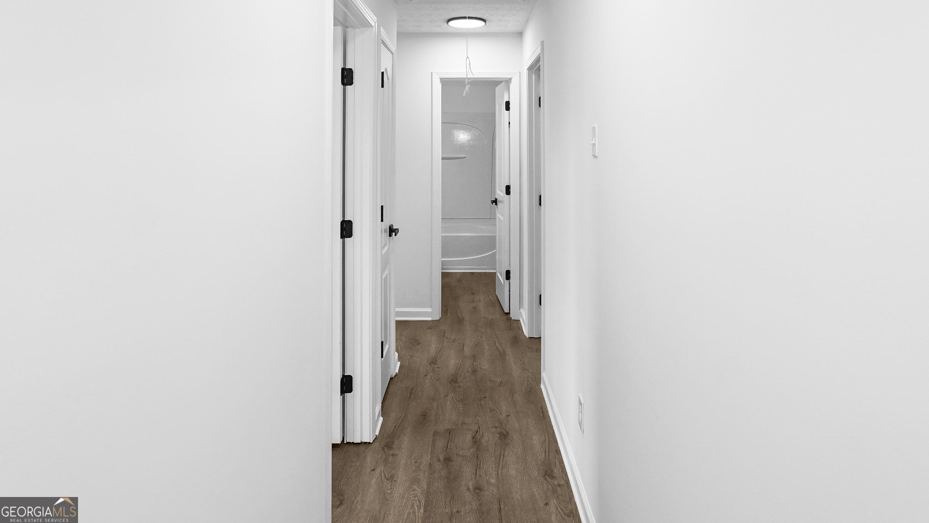 hallway featuring wood-type flooring and a textured ceiling