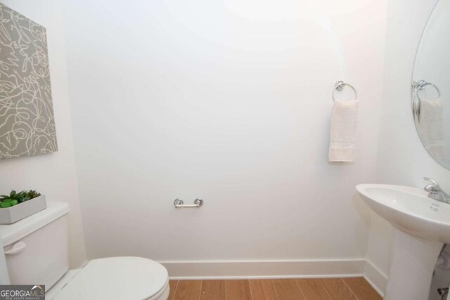 bathroom with hardwood / wood-style flooring, sink, and toilet