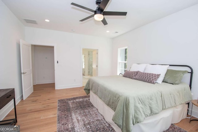 bedroom featuring connected bathroom, ceiling fan, and light hardwood / wood-style flooring