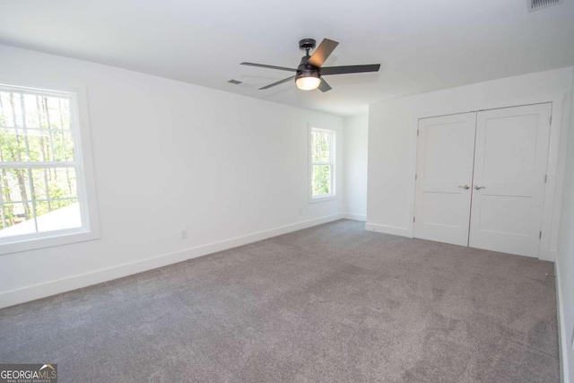 unfurnished bedroom featuring ceiling fan, a closet, and carpet floors