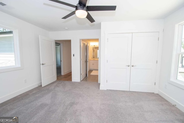 unfurnished bedroom featuring connected bathroom, ceiling fan, a closet, and light carpet