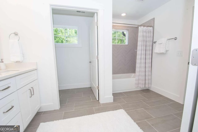 bathroom featuring plenty of natural light, vanity, and shower / bath combo