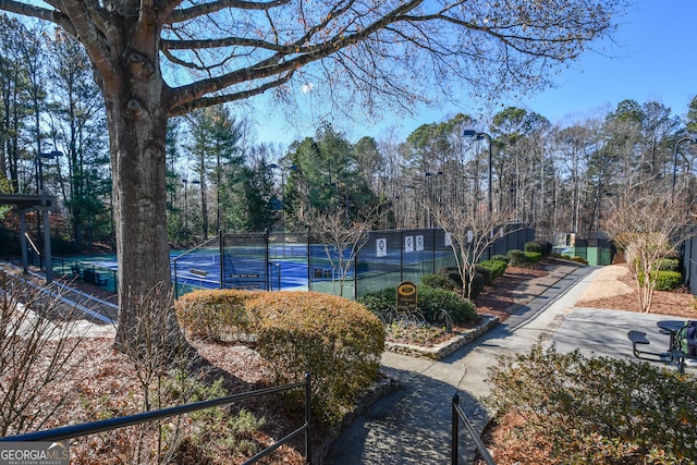 view of home's community featuring tennis court