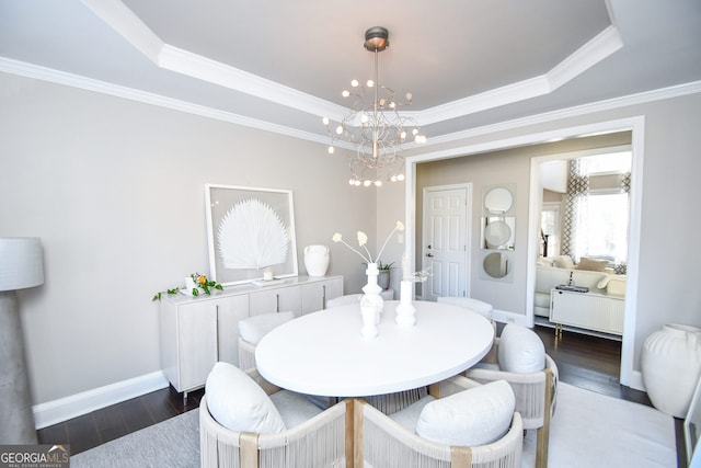 dining area featuring a tray ceiling, crown molding, dark hardwood / wood-style floors, and a notable chandelier