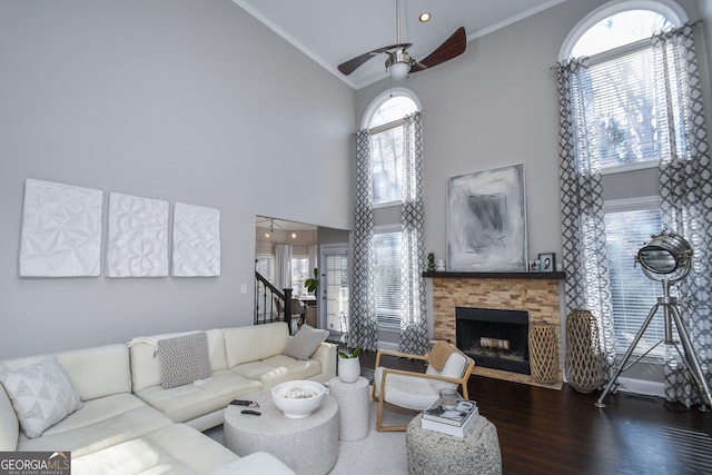 living room featuring crown molding, a fireplace, and a towering ceiling