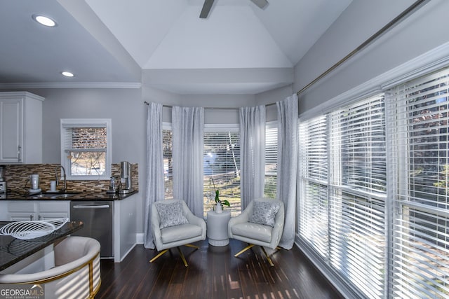 living area with ornamental molding, vaulted ceiling, ceiling fan, dark wood-type flooring, and sink