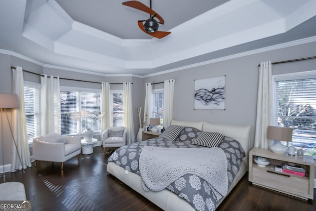 bedroom with crown molding, dark wood-type flooring, and a tray ceiling