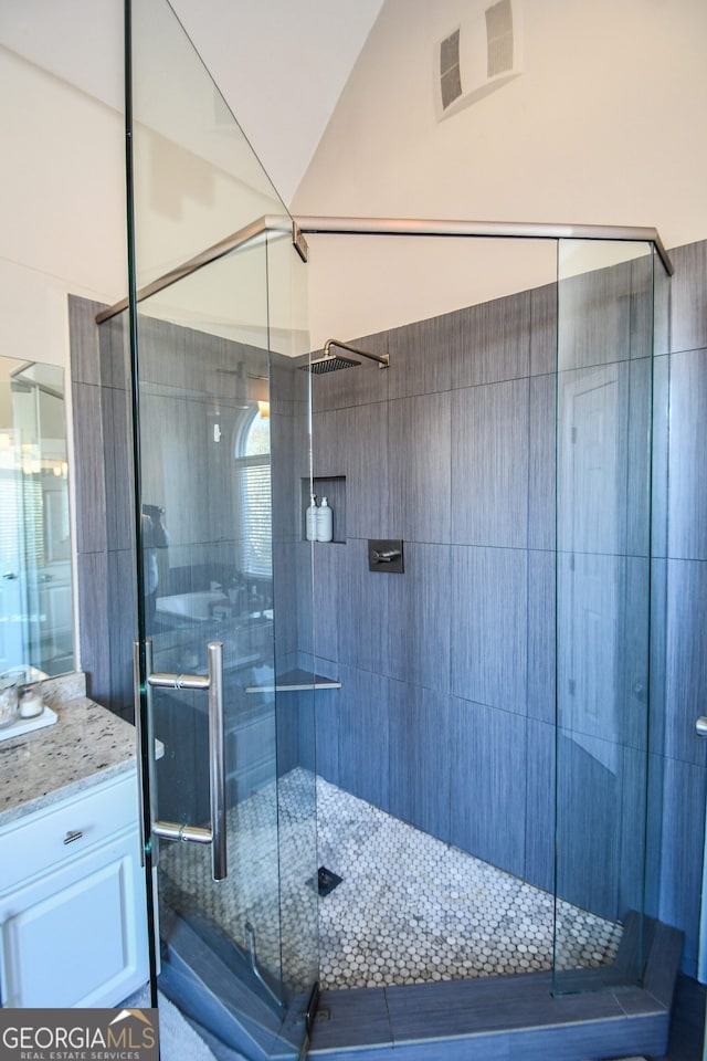 bathroom with vanity and a shower with shower door