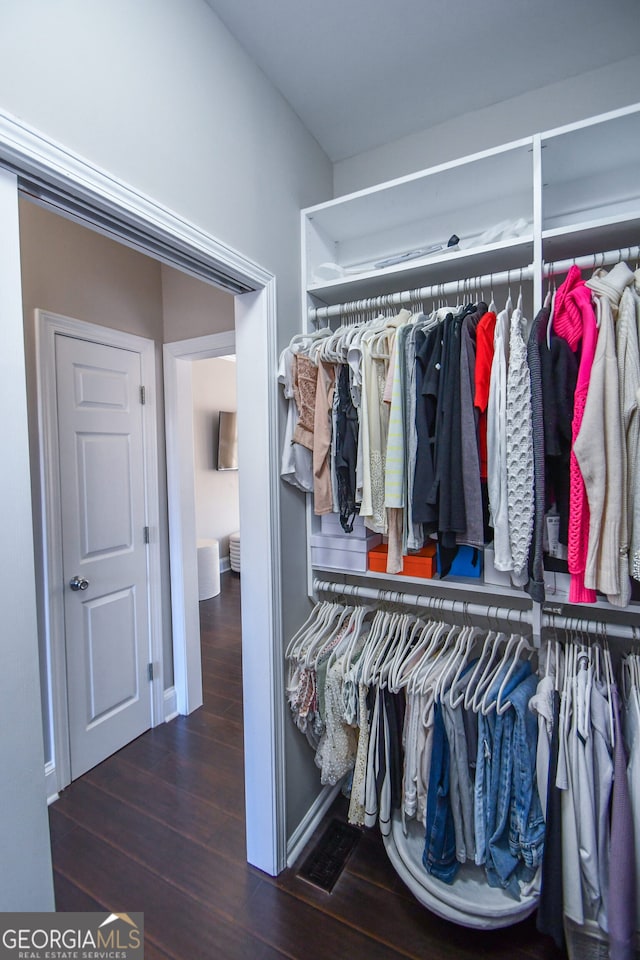 spacious closet featuring dark hardwood / wood-style flooring