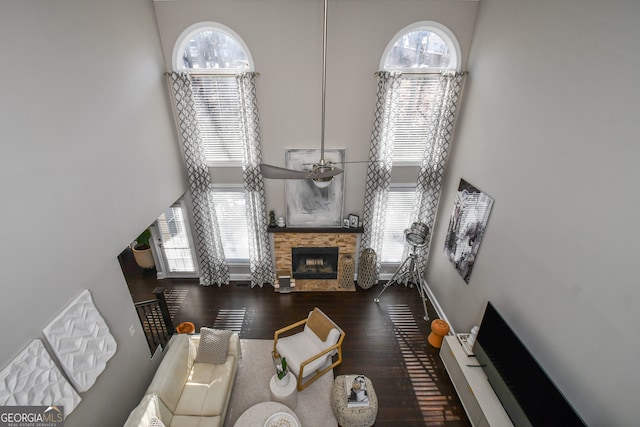 living room featuring a fireplace, a high ceiling, and dark hardwood / wood-style flooring