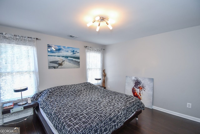 bedroom with dark hardwood / wood-style floors