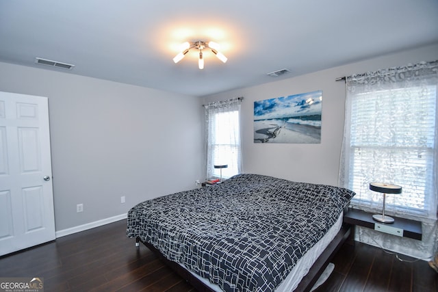 bedroom with dark hardwood / wood-style floors