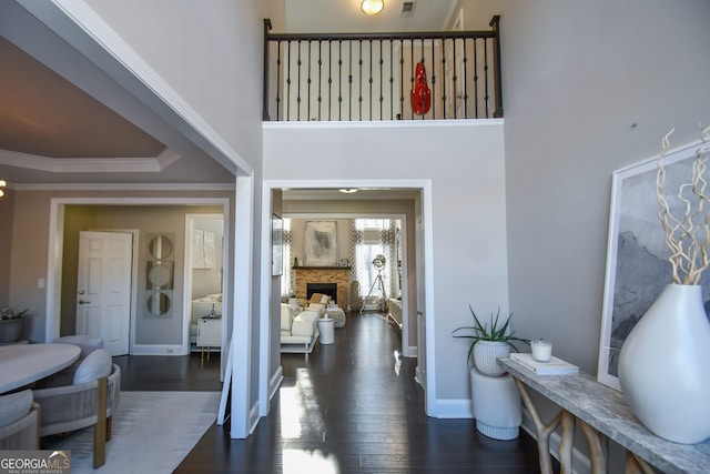 entrance foyer with a stone fireplace and dark hardwood / wood-style flooring