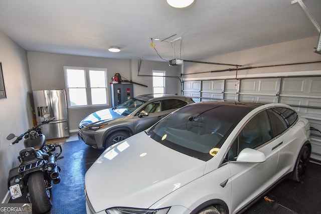 garage with electric panel, stainless steel fridge, and a garage door opener