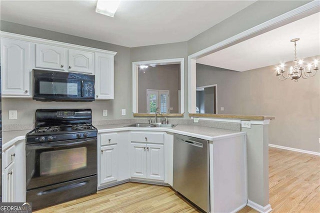 kitchen with an inviting chandelier, black appliances, white cabinets, sink, and kitchen peninsula