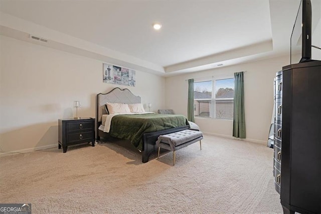 carpeted bedroom featuring a raised ceiling