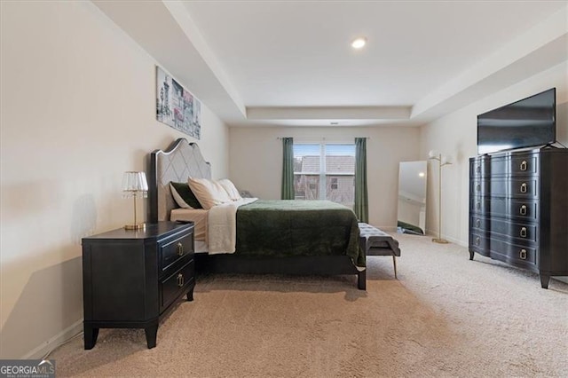 carpeted bedroom featuring a raised ceiling