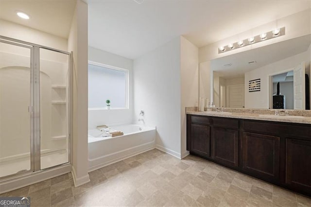 bathroom with vanity and shower with separate bathtub