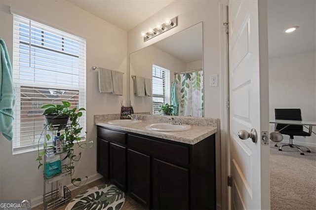 bathroom featuring a shower with curtain, vanity, and a healthy amount of sunlight