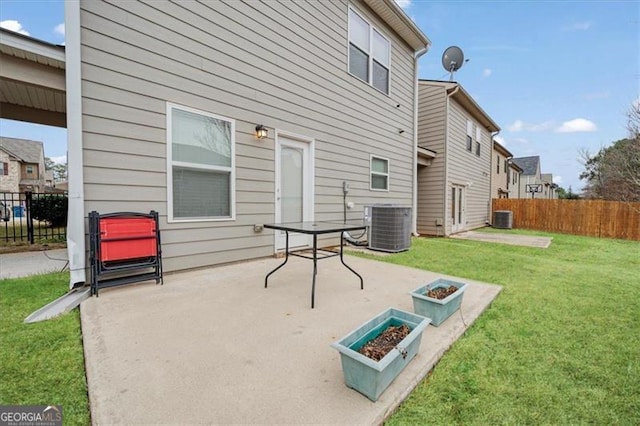 rear view of property with a yard, cooling unit, and a patio