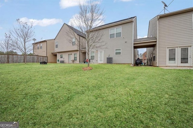 back of property with a lawn and central air condition unit