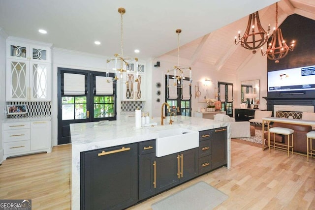 kitchen featuring decorative light fixtures, white cabinetry, sink, and french doors