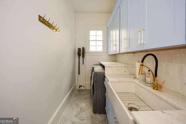 laundry room with cabinets, washer and clothes dryer, and sink