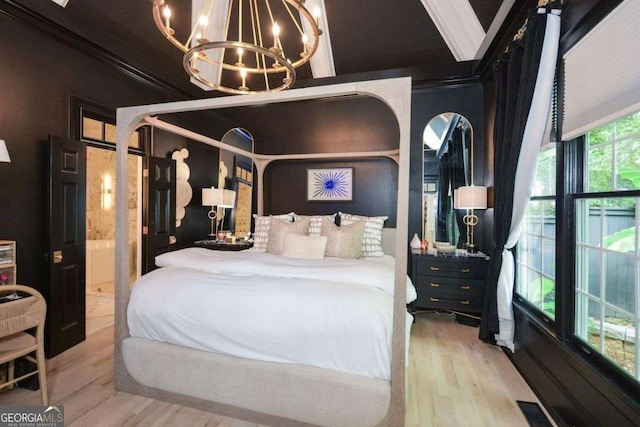 bedroom with ornamental molding, a chandelier, and light hardwood / wood-style flooring