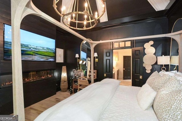 bedroom with hardwood / wood-style floors, crown molding, and a chandelier