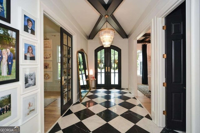 entryway featuring lofted ceiling, a notable chandelier, and french doors