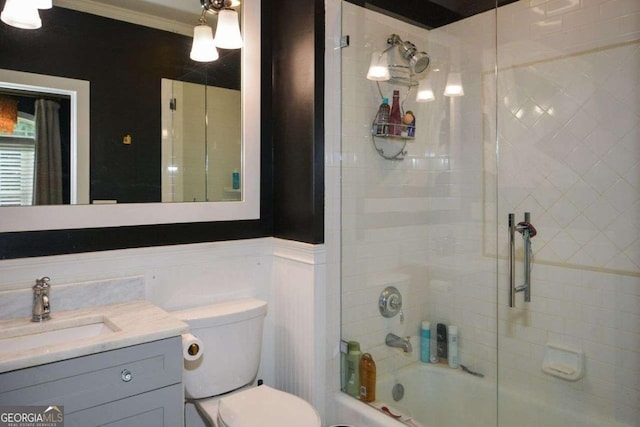 full bathroom with toilet, ornamental molding, vanity, and bath / shower combo with glass door