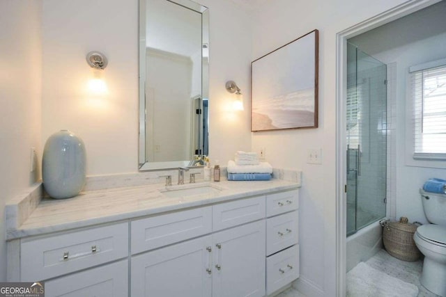 full bathroom with vanity, bath / shower combo with glass door, and toilet