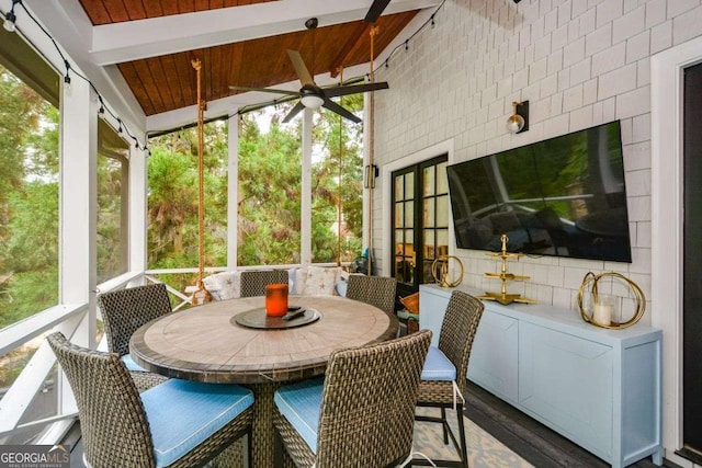 sunroom / solarium with beamed ceiling, wooden ceiling, and ceiling fan