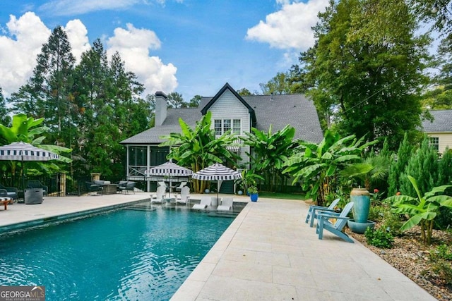 view of pool featuring a sunroom and a patio