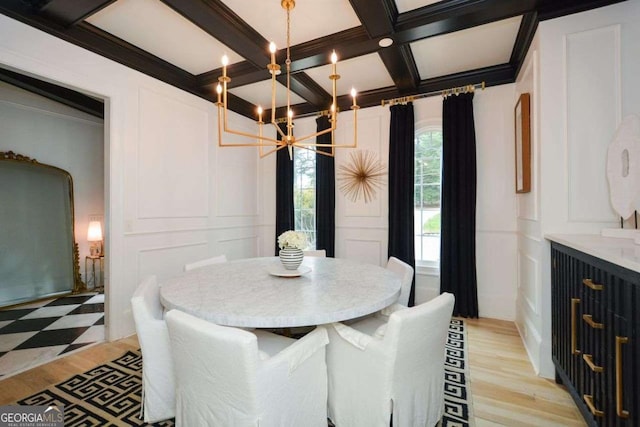 dining space with coffered ceiling, a chandelier, ornamental molding, beam ceiling, and light hardwood / wood-style floors