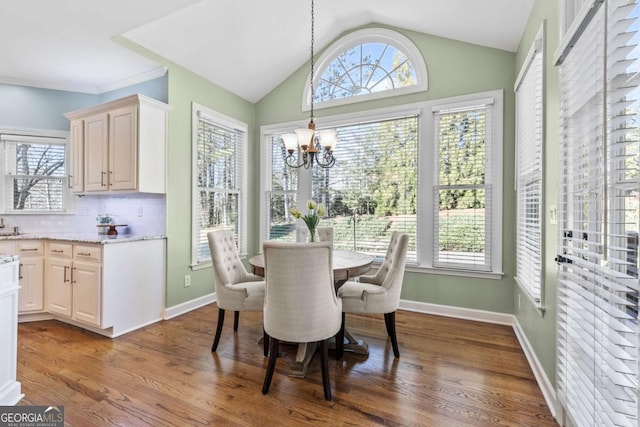 dining room with a chandelier, vaulted ceiling, and hardwood / wood-style flooring