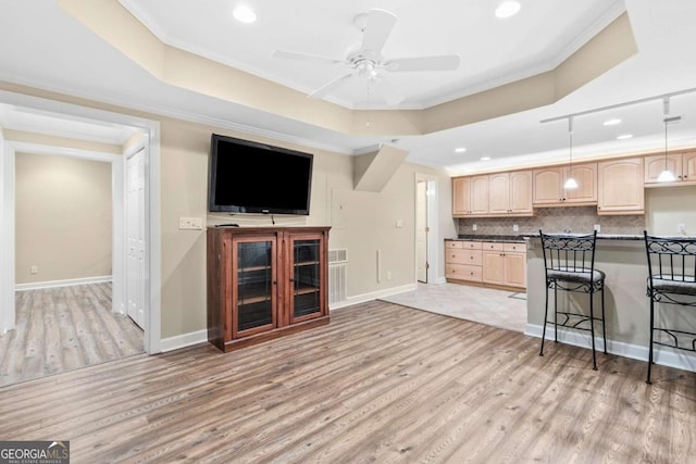 kitchen featuring pendant lighting, crown molding, a breakfast bar area, and light brown cabinetry