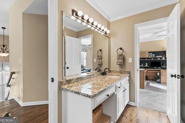 bathroom featuring hardwood / wood-style floors, vanity, a healthy amount of sunlight, and crown molding