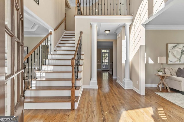 foyer with decorative columns, light hardwood / wood-style flooring, and ornamental molding