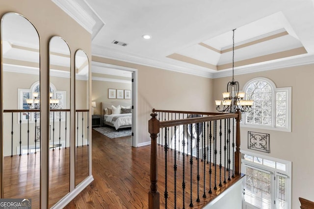 stairway featuring a raised ceiling, crown molding, a wealth of natural light, and a notable chandelier