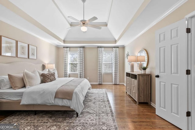 bedroom featuring dark hardwood / wood-style flooring, a raised ceiling, ceiling fan, and crown molding